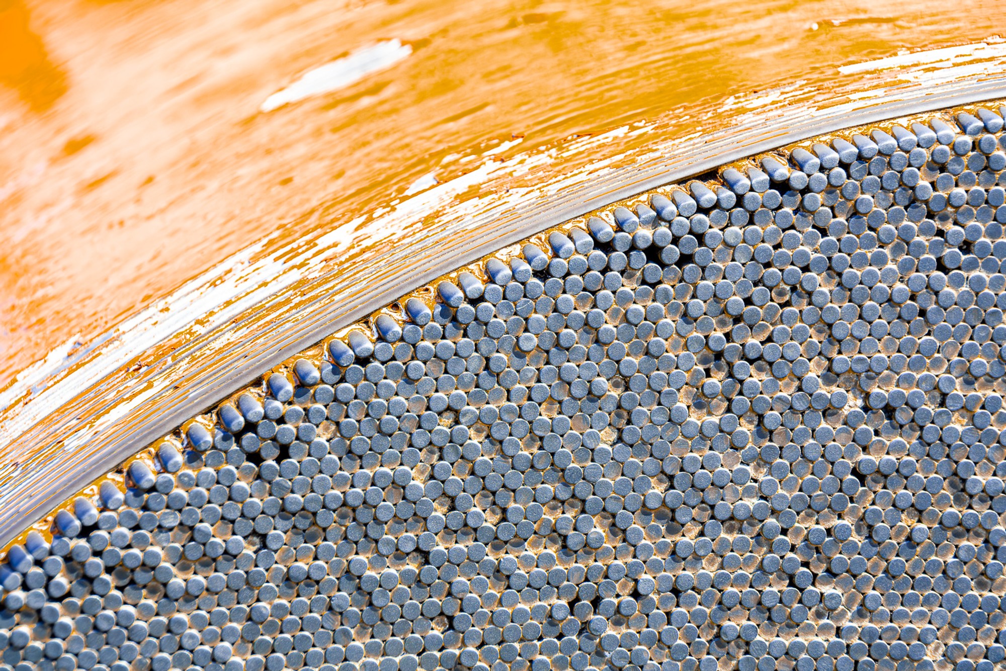 The main suspension cable of the Golden Gate Bridge photographed close, the individual steel strands of which it is composed visible at the surface. The cable that carries the bridge, examined at the wire.
