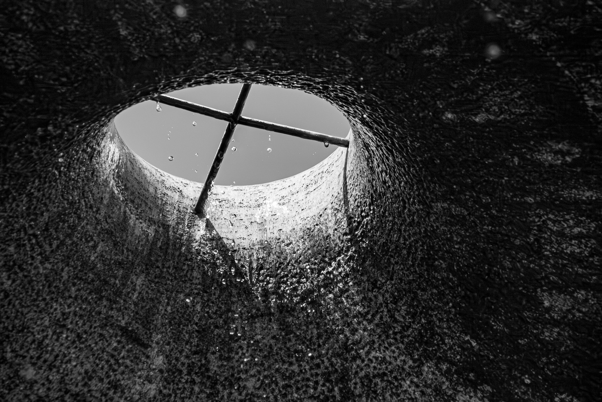 Looking straight up at the concrete ceiling of rain drain, the texture and grey tones filling the frame entirely. Infrastructure at the scale of a city - photographed as though it were landscape.