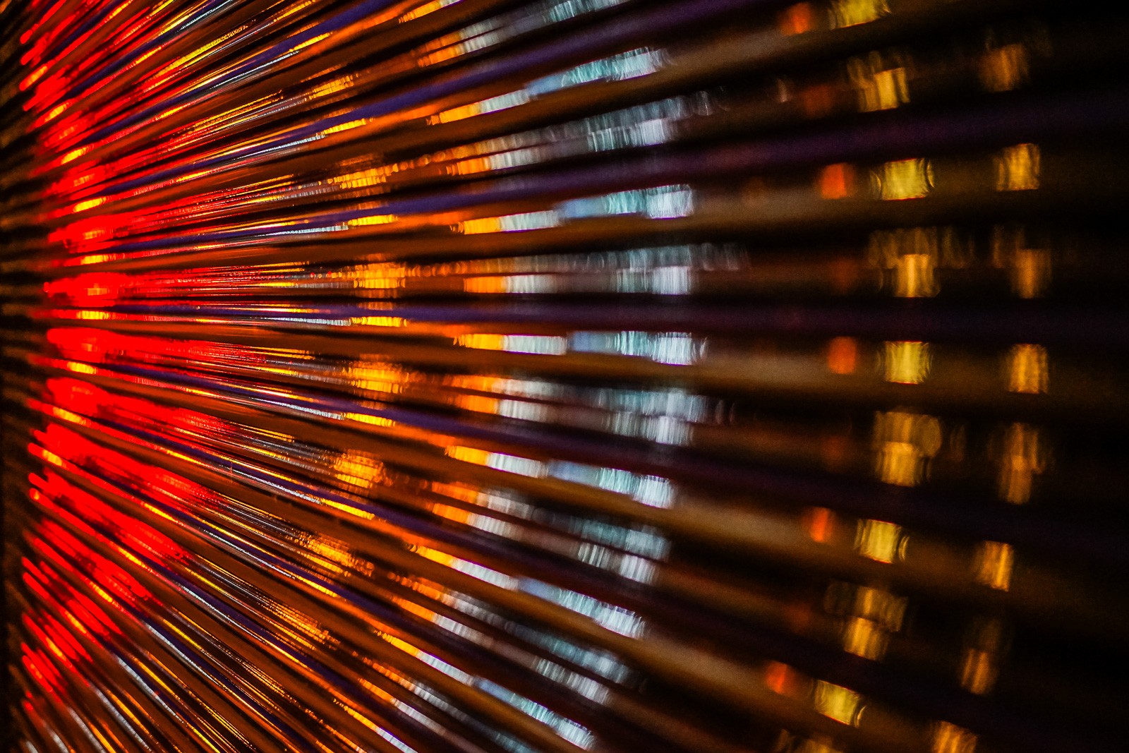 A corrugated metal roller door in London, wet from rain, its ridged surface catching and distorting the street light right in front of it. The city compressed and stretched across every fold - reflected in its own infrastructure.