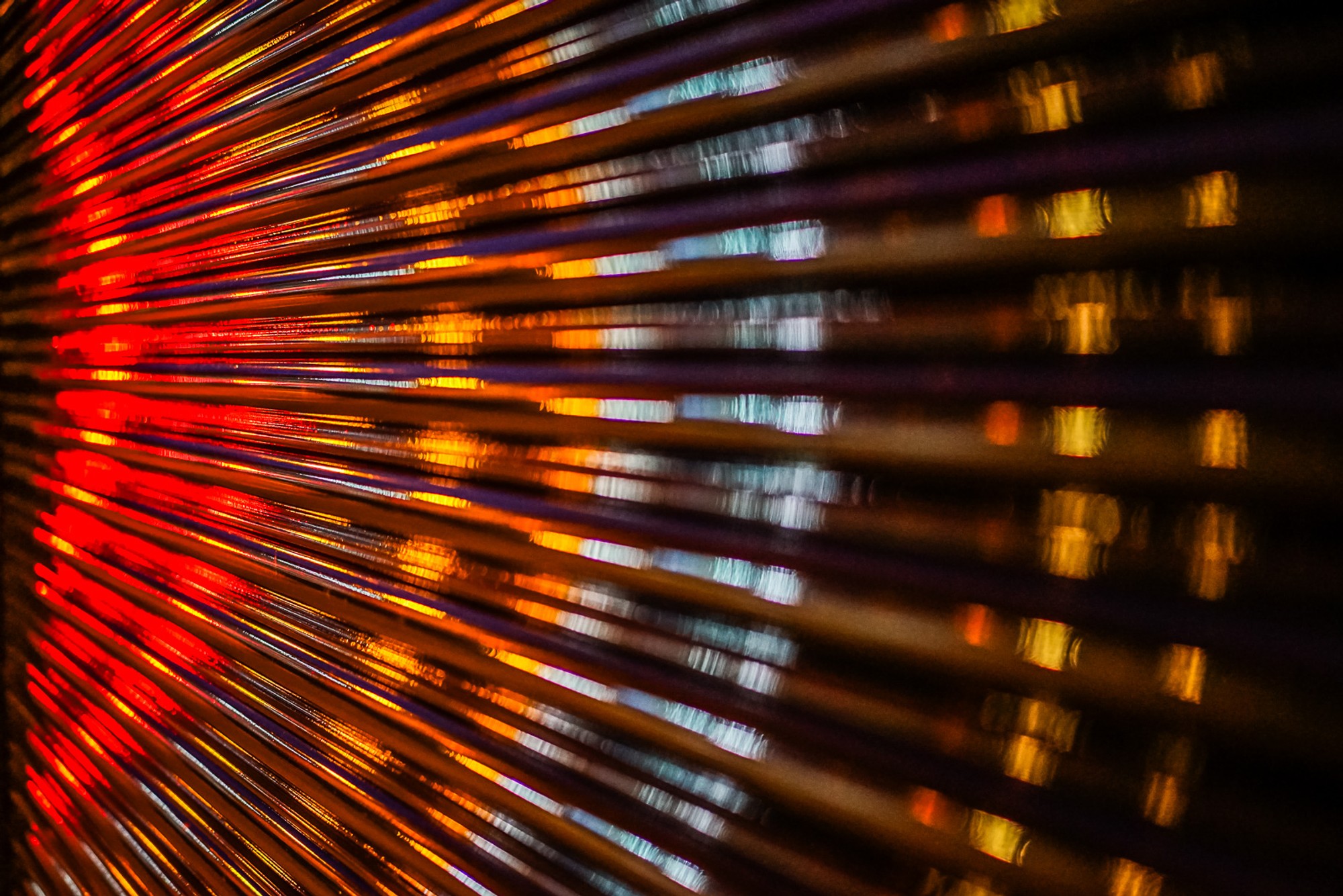 A corrugated metal roller door in London, wet from rain, its ridged surface catching and distorting the street light right in front of it. The city compressed and stretched across every fold - reflected in its own infrastructure.