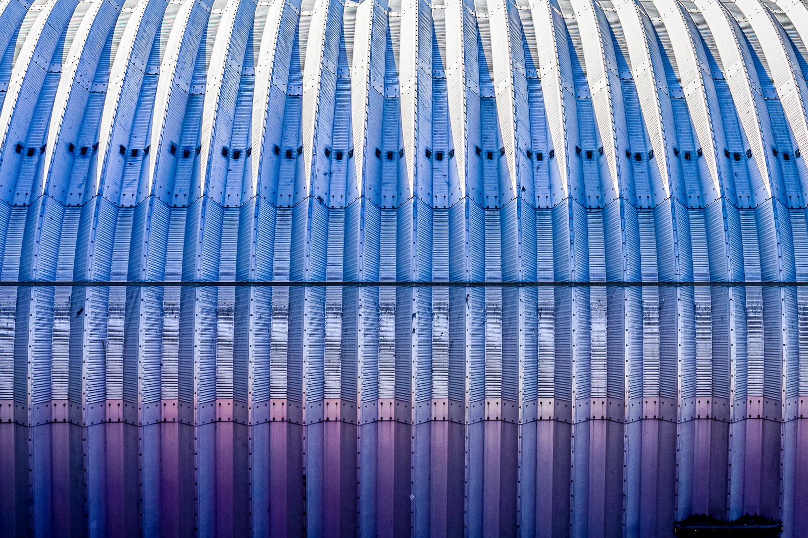 A corrugated metal storage facade in New York photographed close, the folds creating a repeating pattern of ridges and shadow. The utilitarian structure reveals unexpected precision when the context is removed.