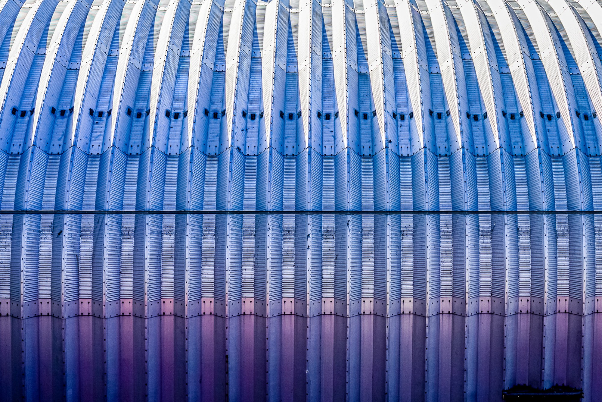 A corrugated metal storage facade in New York photographed close, the folds creating a repeating pattern of ridges and shadow. The utilitarian structure reveals unexpected precision when the context is removed.