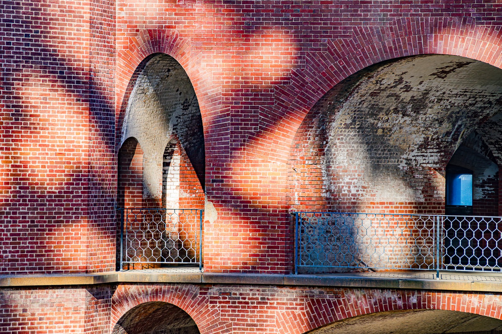 The brick-vaulted corridors of Fort Point - the Civil War fortress built directly beneath the Golden Gate Bridge - photographed in black and white. The arches repeat and recede, the shadows between them precise and deep.