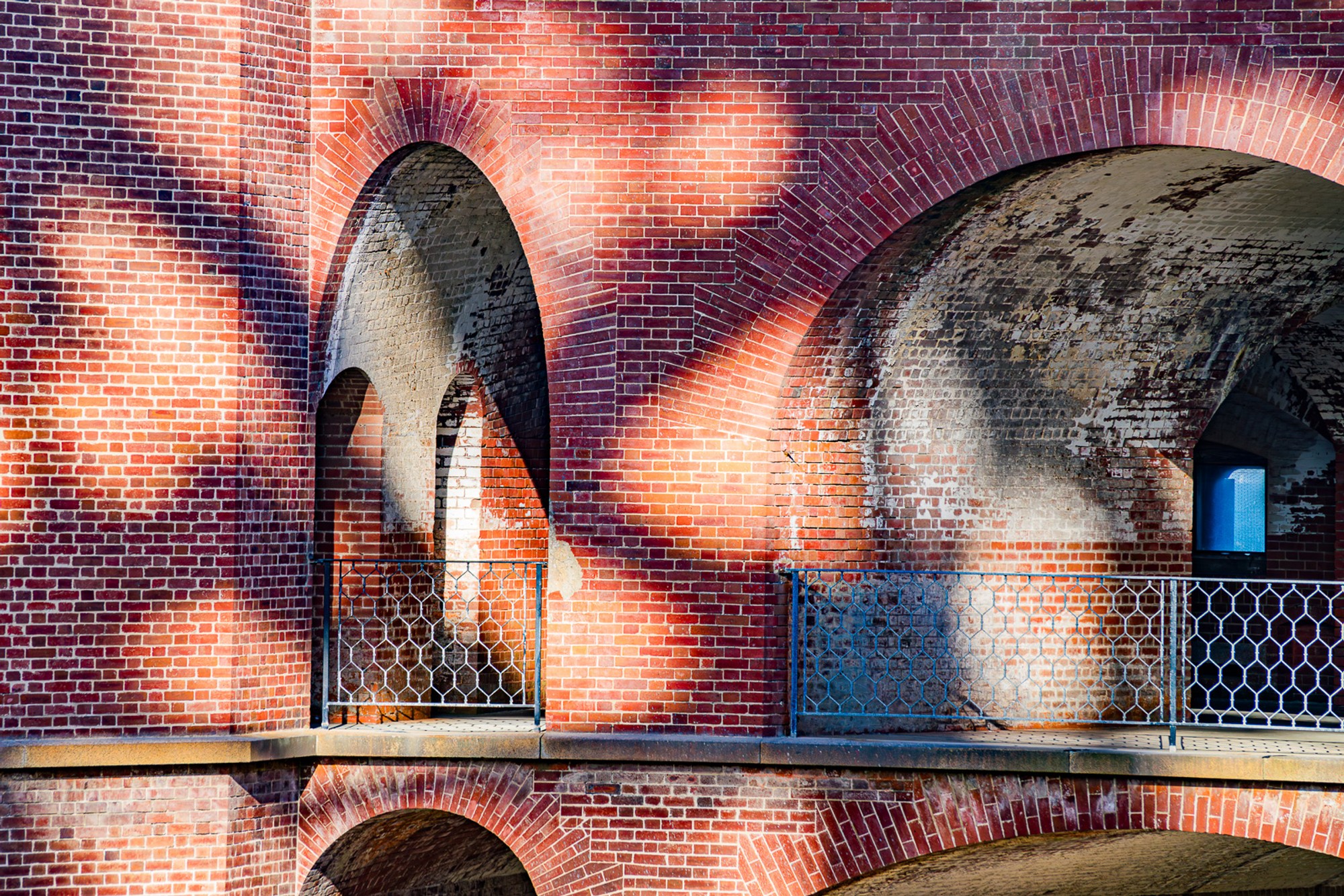 The brick-vaulted corridors of Fort Point - the Civil War fortress built directly beneath the Golden Gate Bridge - photographed in black and white. The arches repeat and recede, the shadows between them precise and deep.