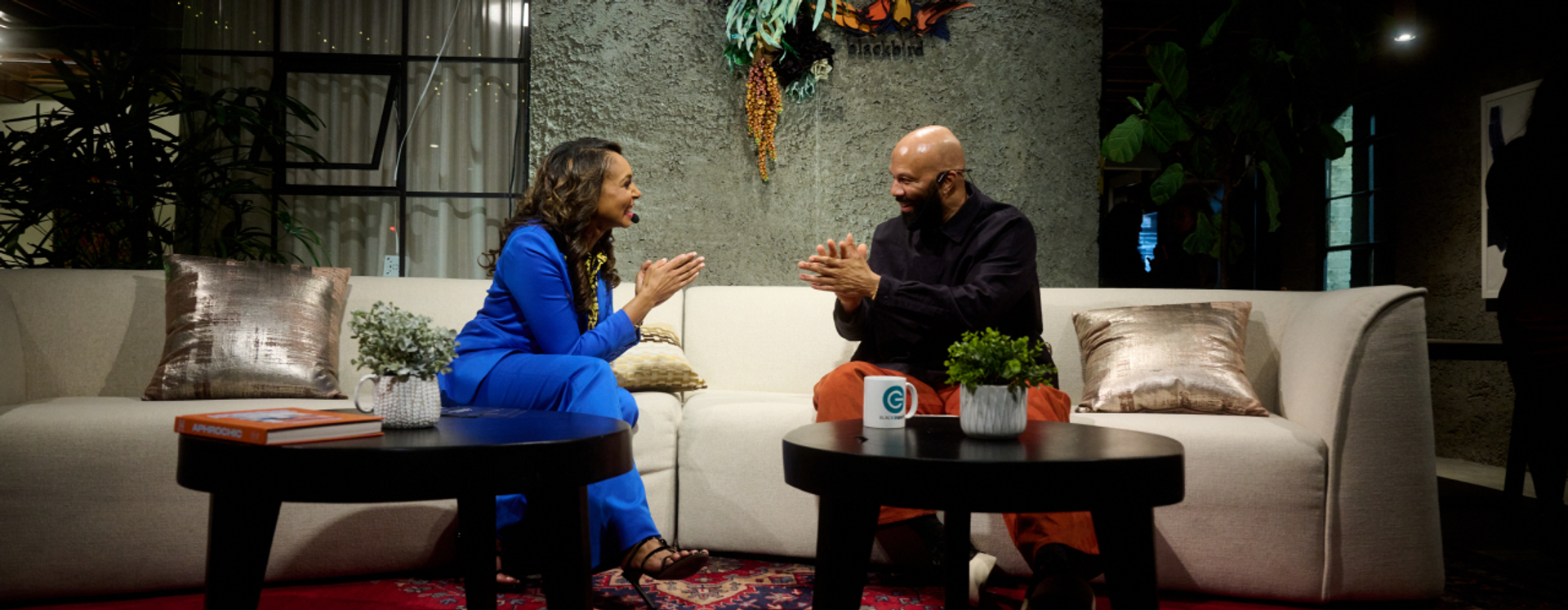 Kaci Patterson and Common seated in conversation at the Collective Conversations fireside chat