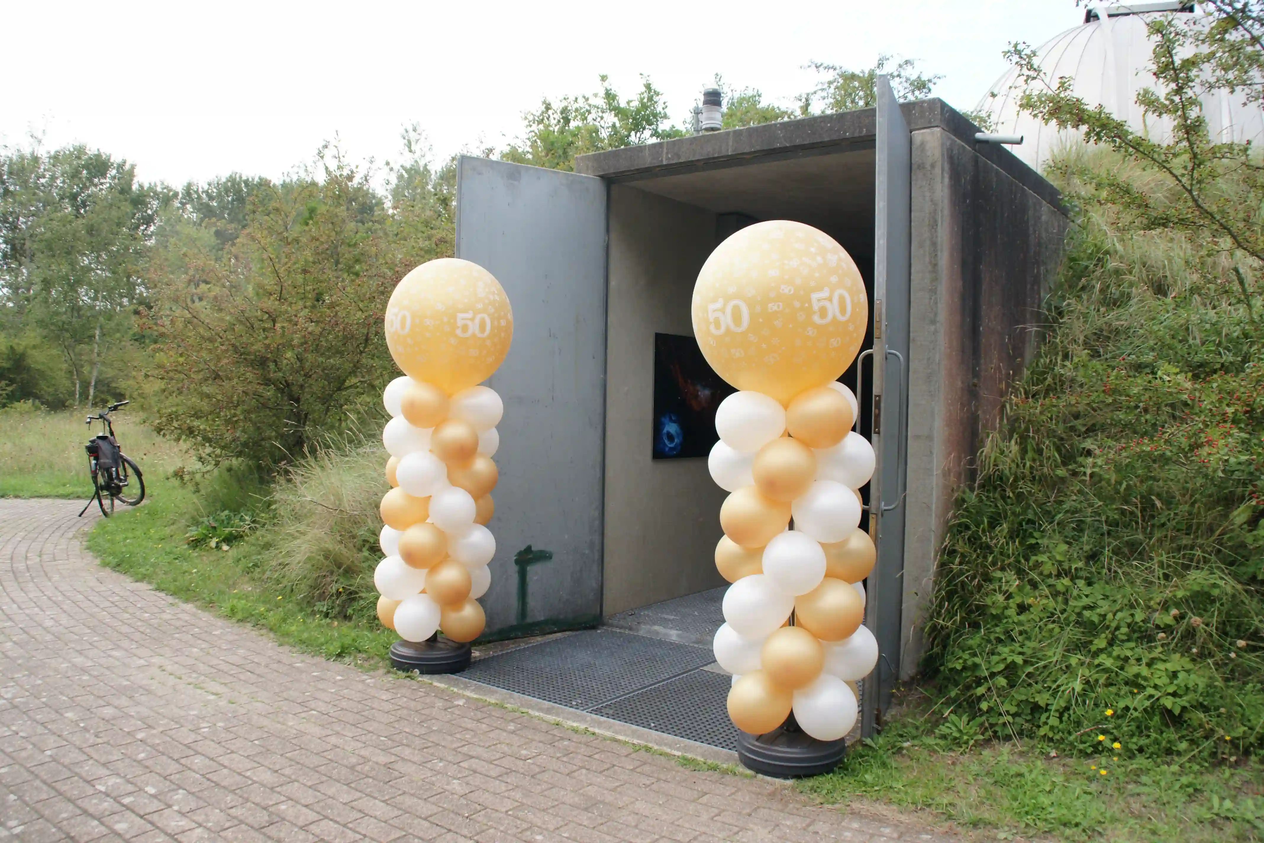 Jubileum opening met ballonnen naast de ingang