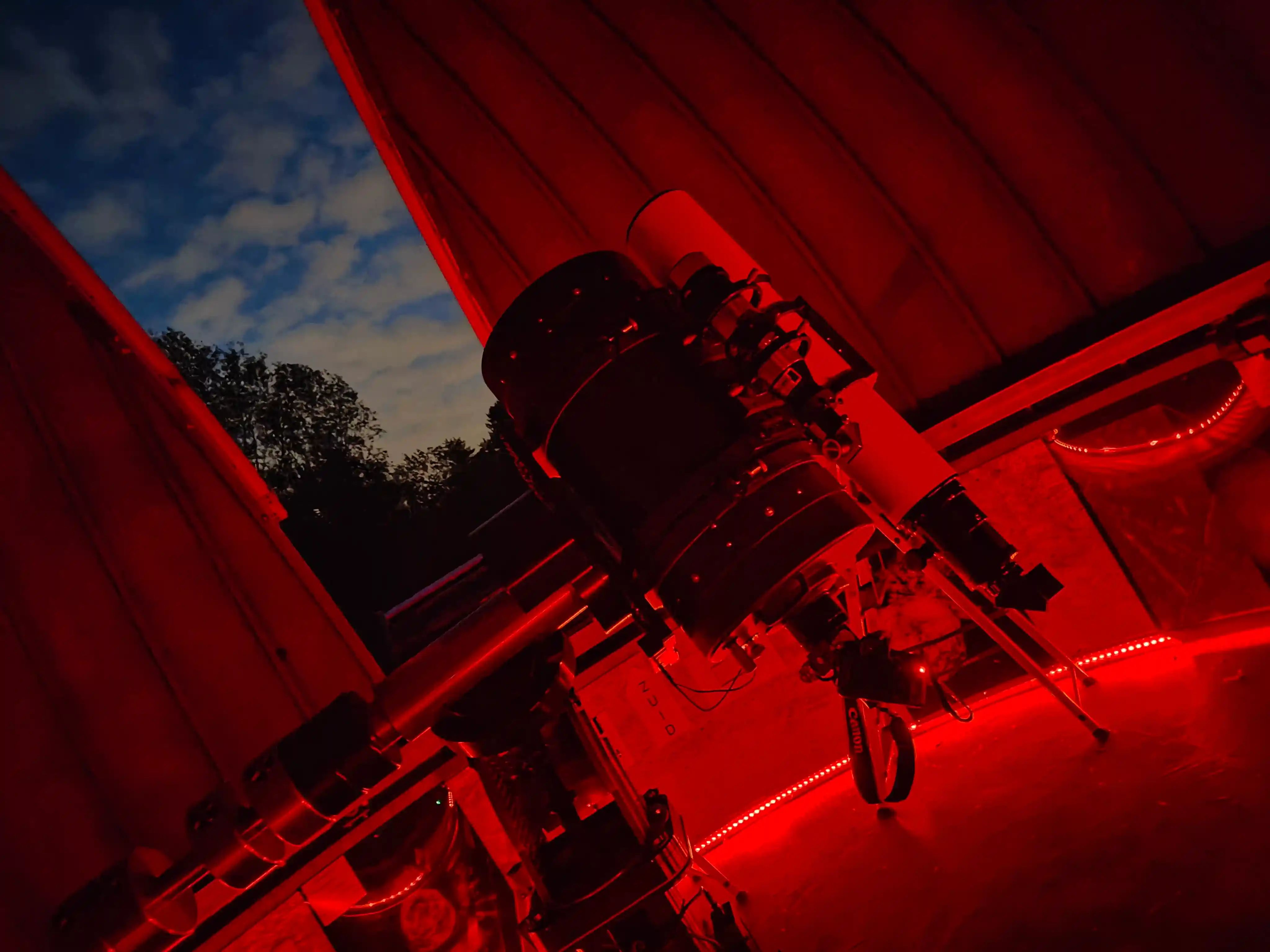 Telescoop kijkt naar schermer in de rood verlichte koepel