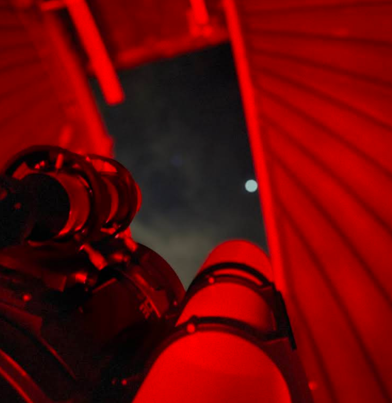 Zicht op de maan langs onze telescoop in de rood belichte koepel