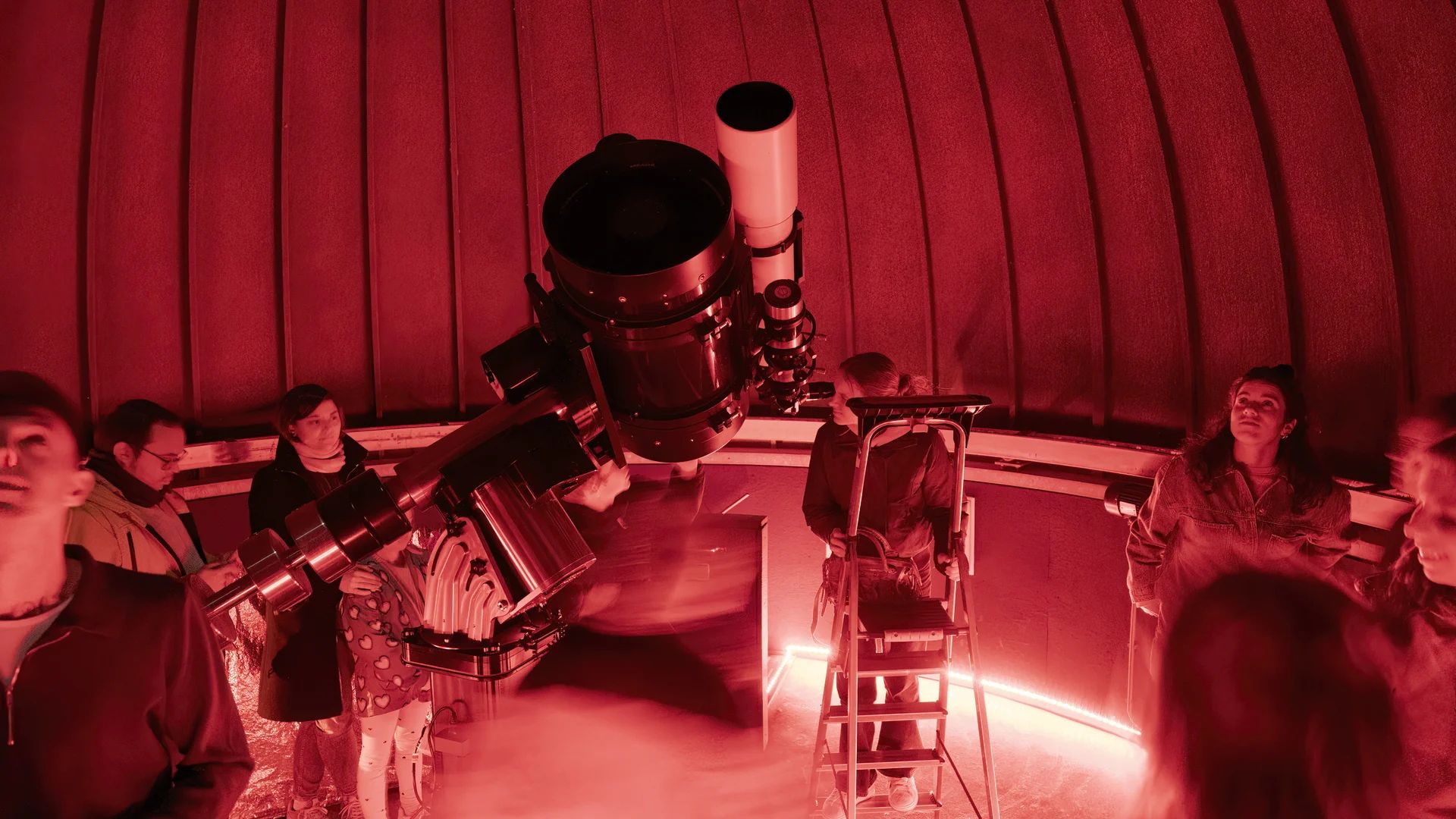 Groep mensen in de rood verlichte koepel