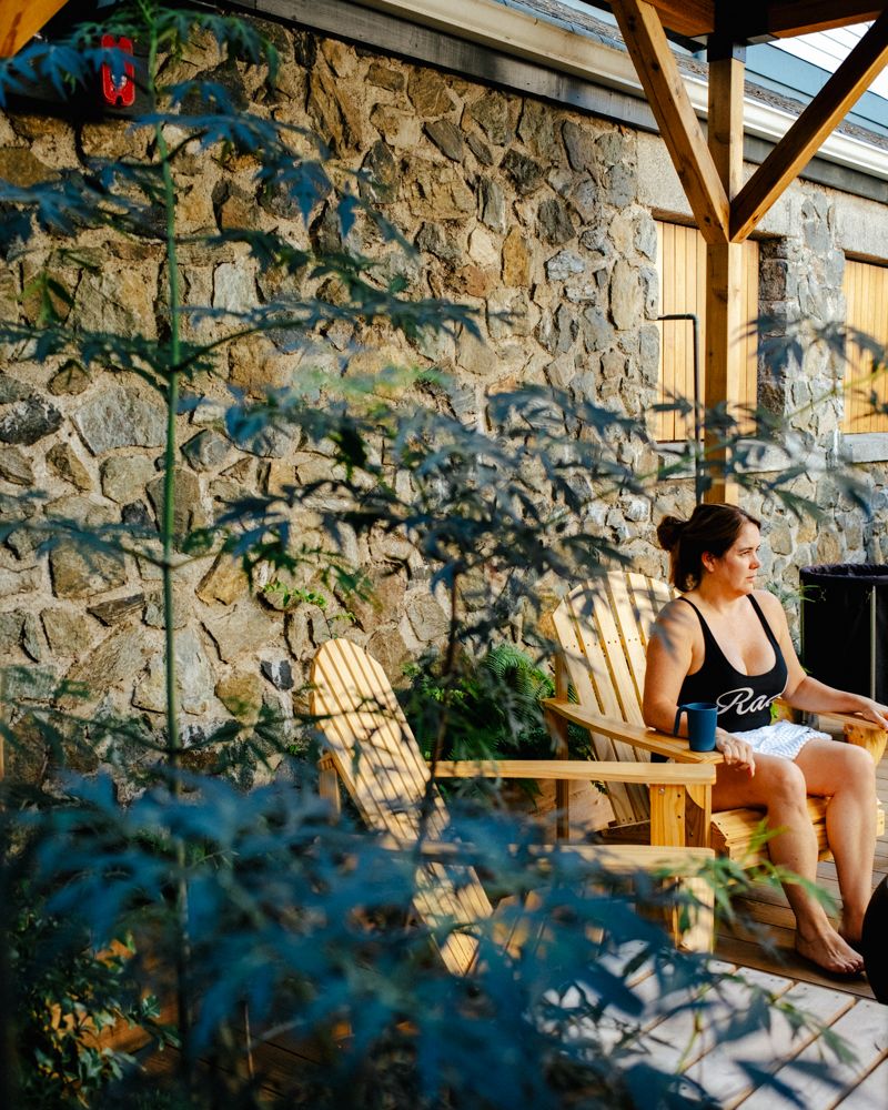 Guest resting beside the stone wall in Aerth's sunlit courtyard.