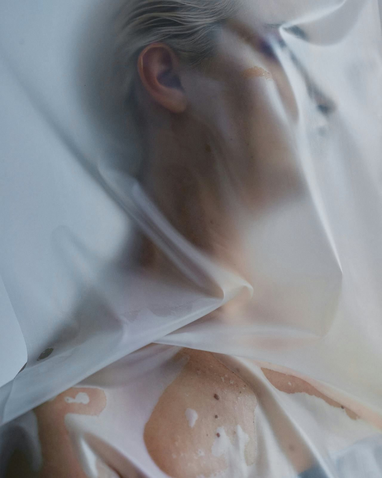 Portrait seen through a translucent fabric veil.
