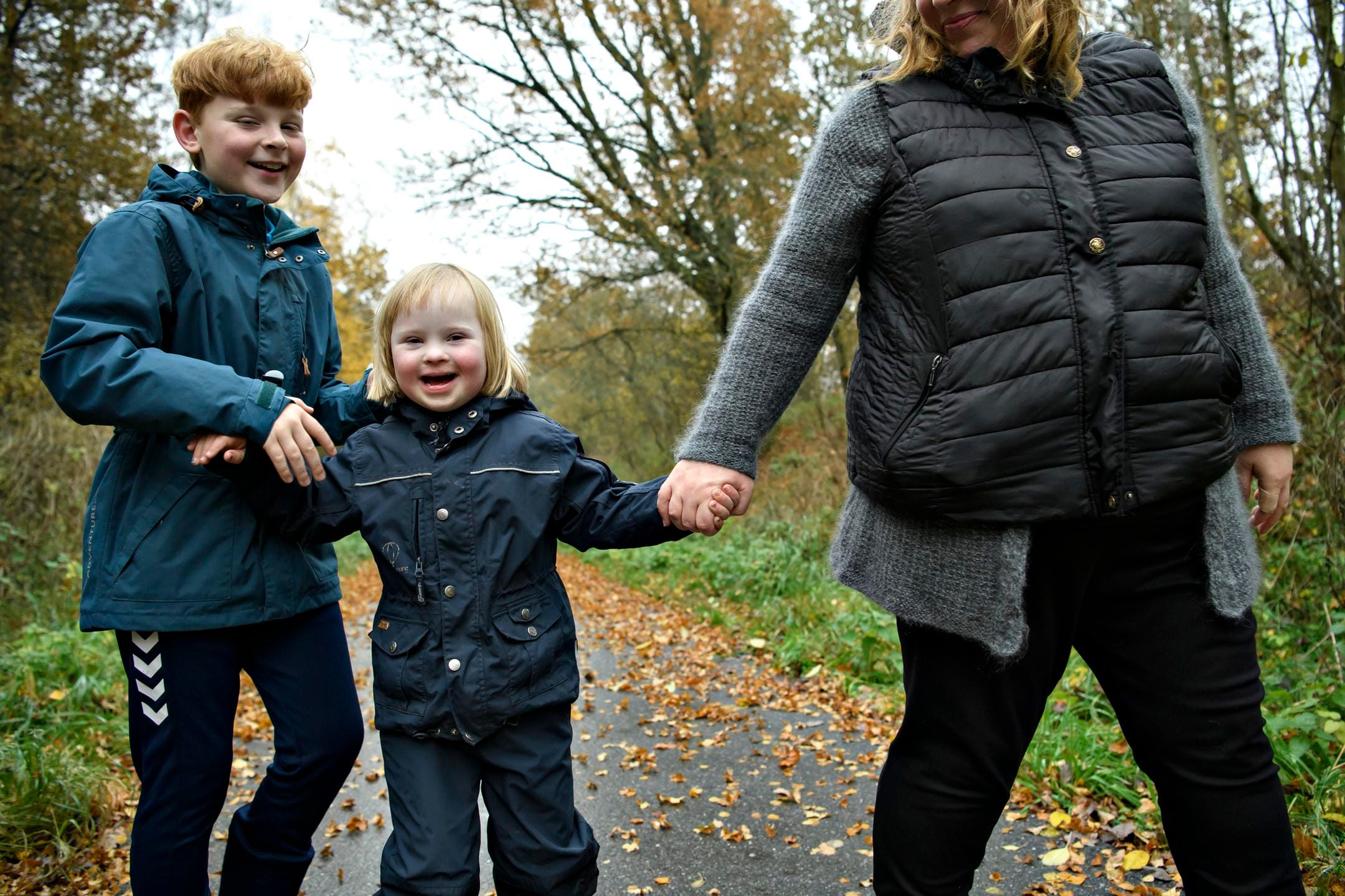 Mor holder i hånd med sine to børn