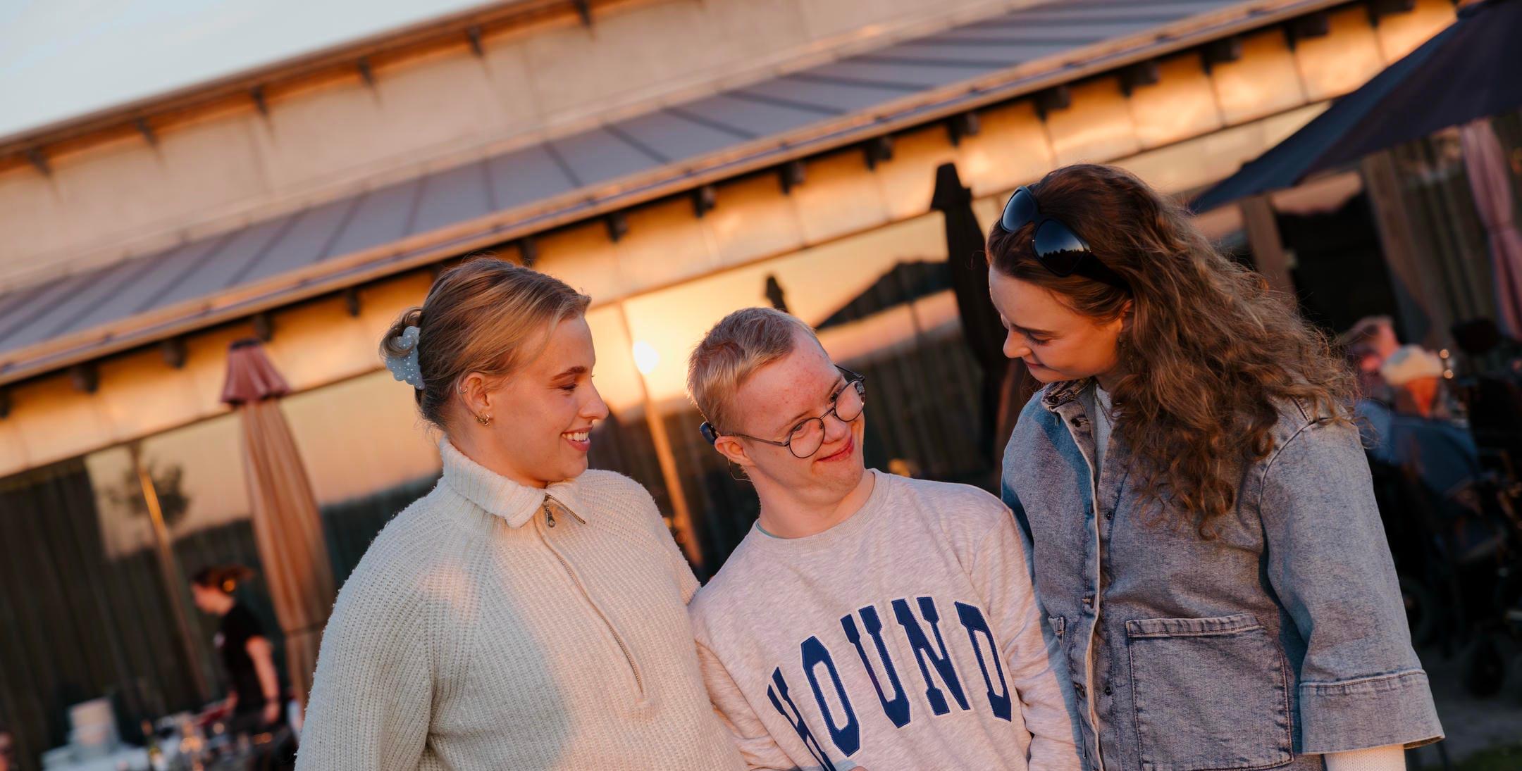 Tre unge står sammen og griner