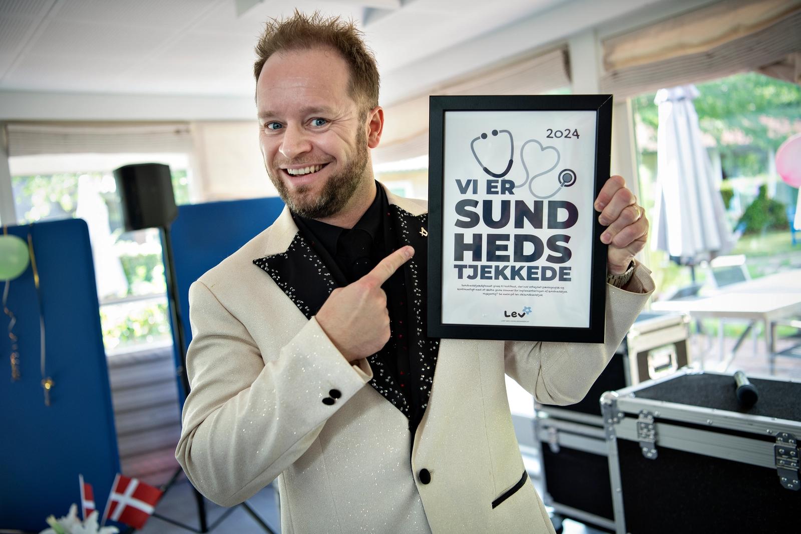 Mand står med Sundhedstjek-diplom