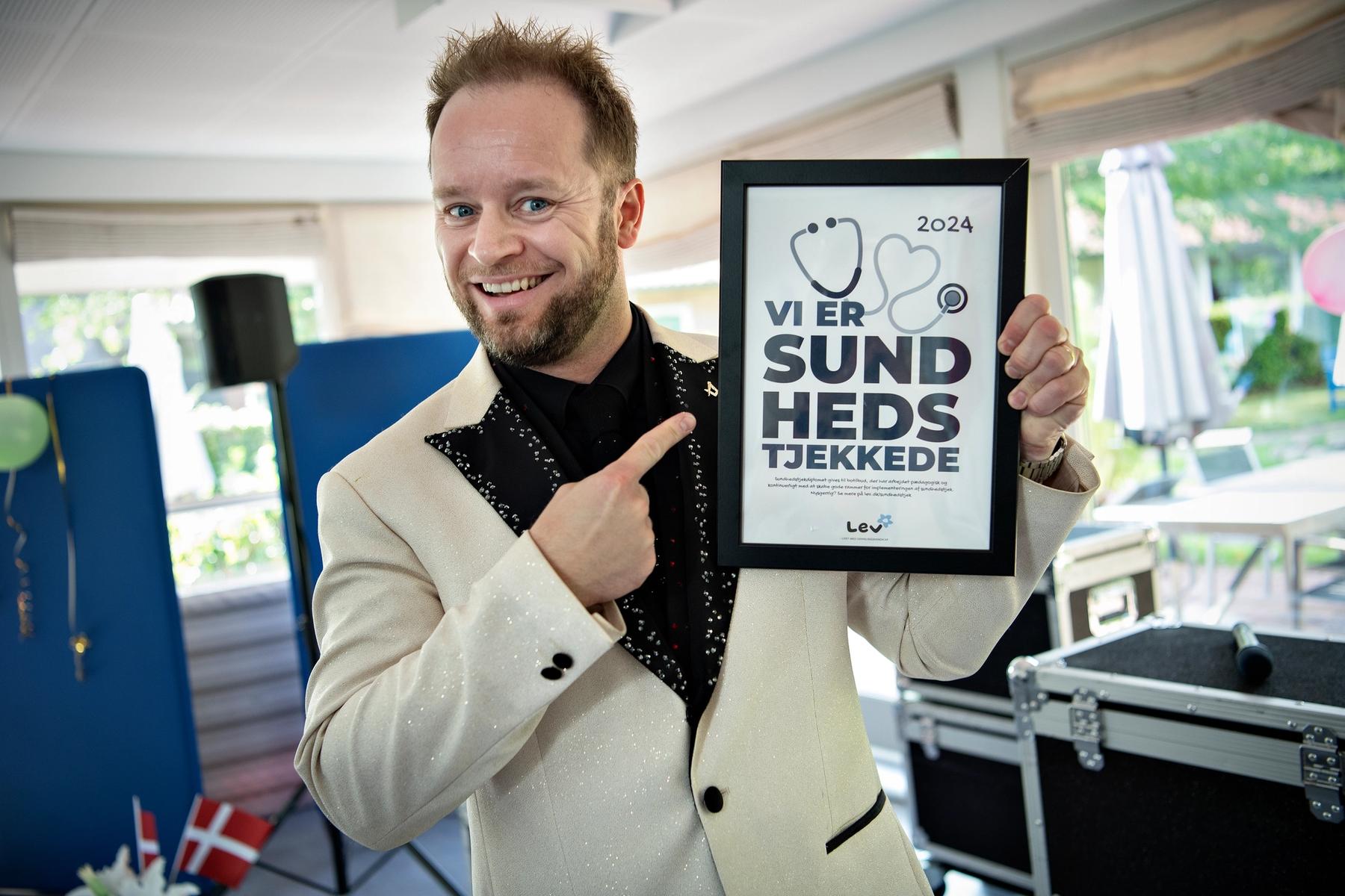 Mand står med Sundhedstjek-diplom