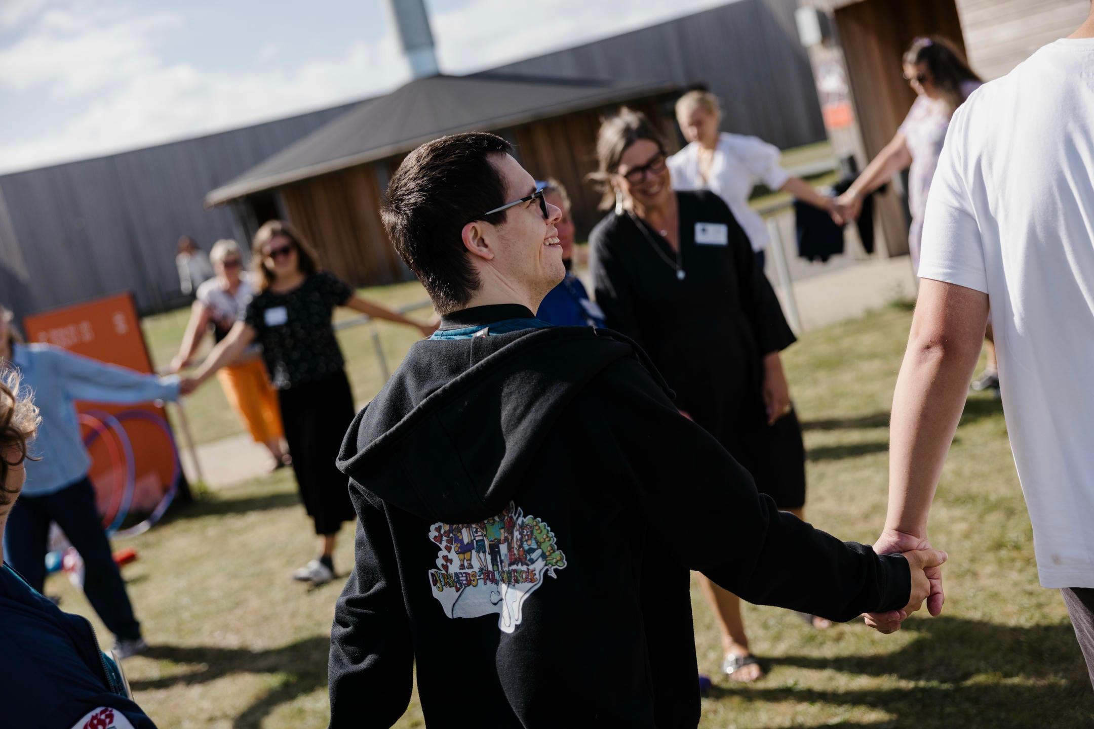 Unge mennesker holder i hånd og leger