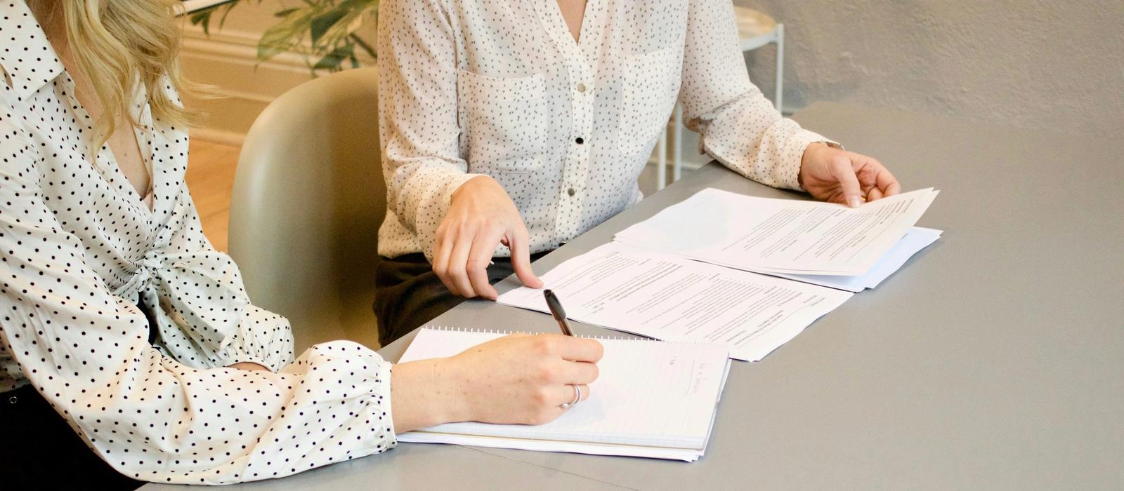 To personer gennemgår mødepapirer