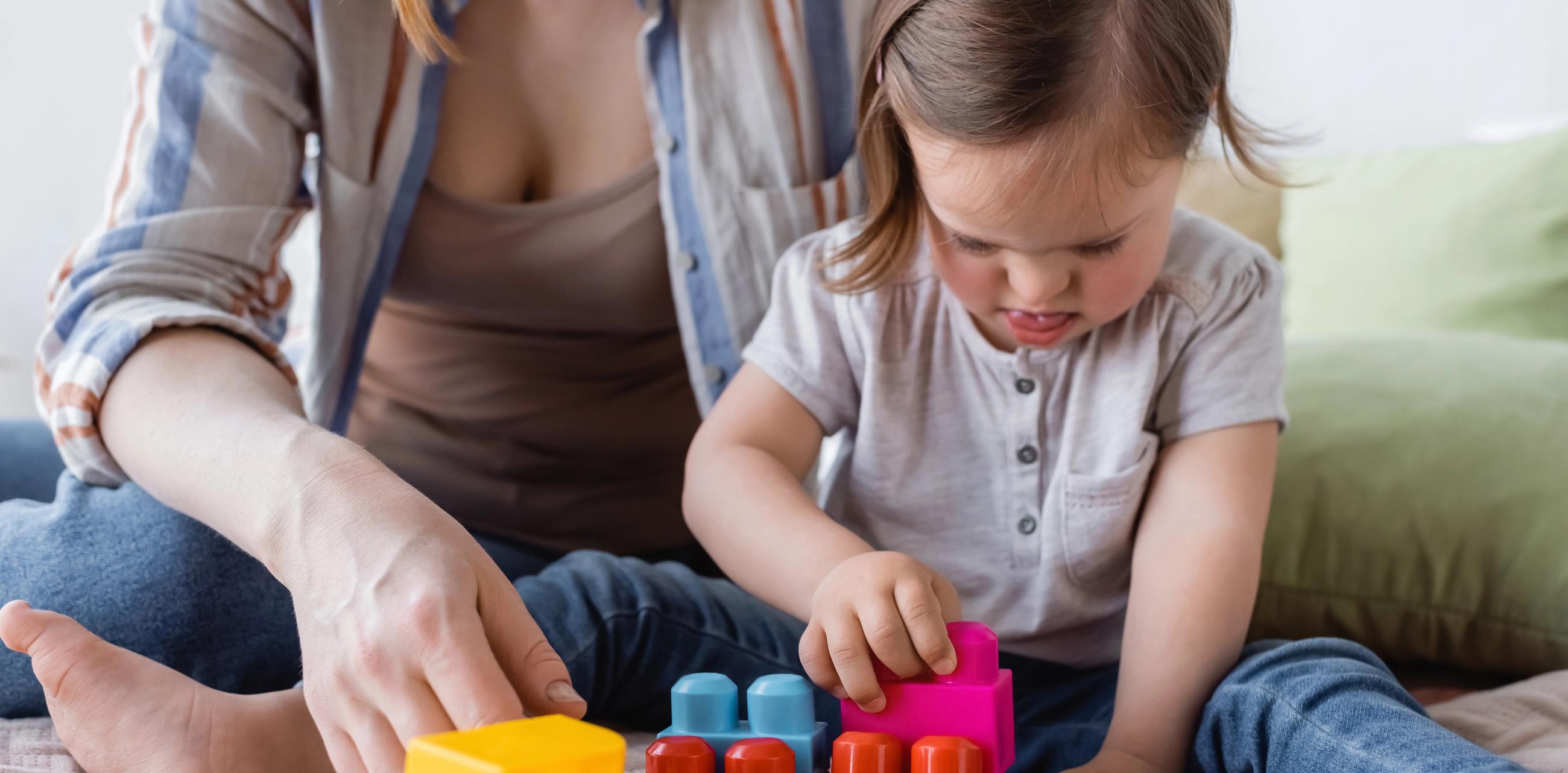 Mor og datter leger med legetøj indenfor