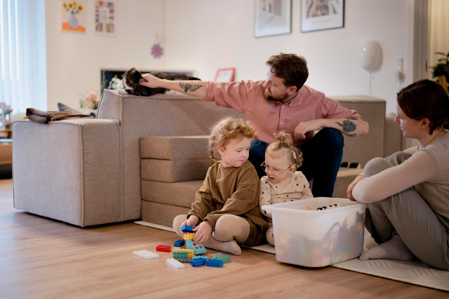Familie sidder sammen og leger på gulvet