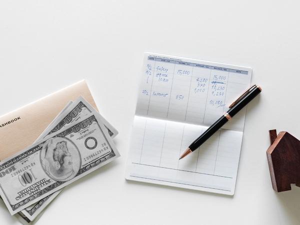 Des billets et un carnet sur comment investir son argent