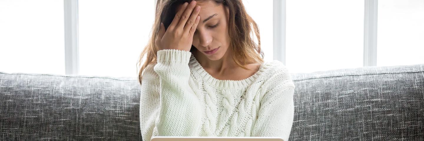 Une femme dépitée devant un ordinateur