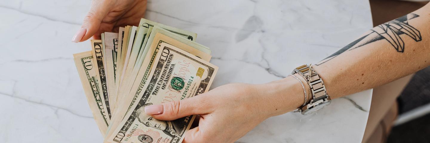 Une personne tient des billets dans ses mains
