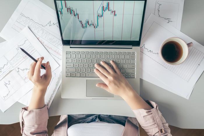 Une femme en train de choisir dans quoi investir sur ordinateur