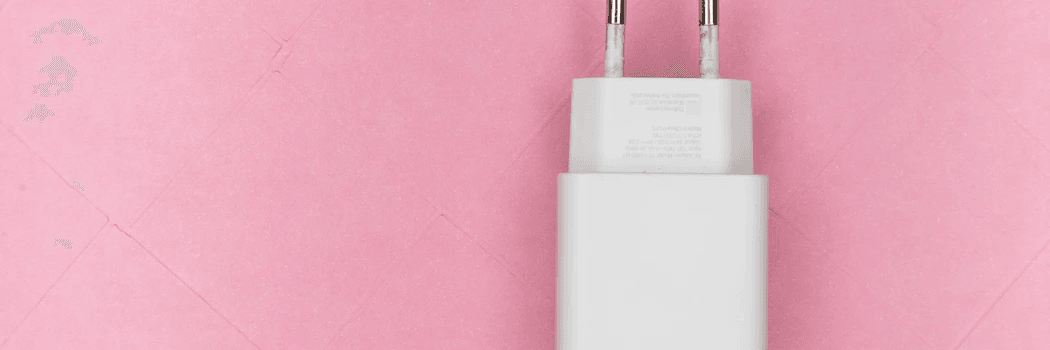 Un chargeur de téléphone sur fond rose