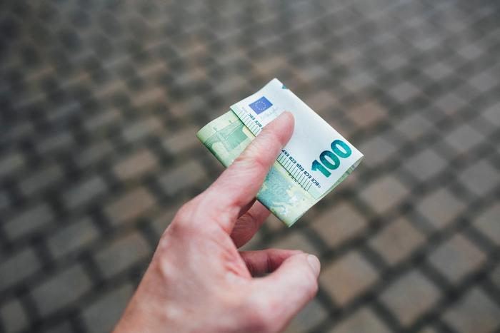 Des billets de 100 euros dans une main