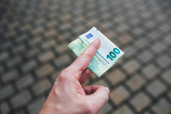 Des billets de 100 euros dans une main