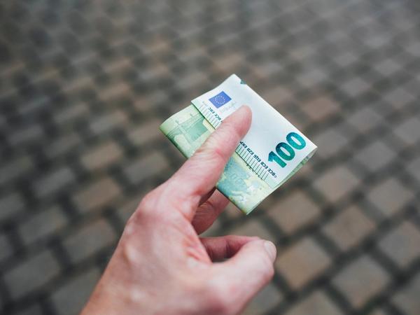 Des billets de 100 euros dans une main