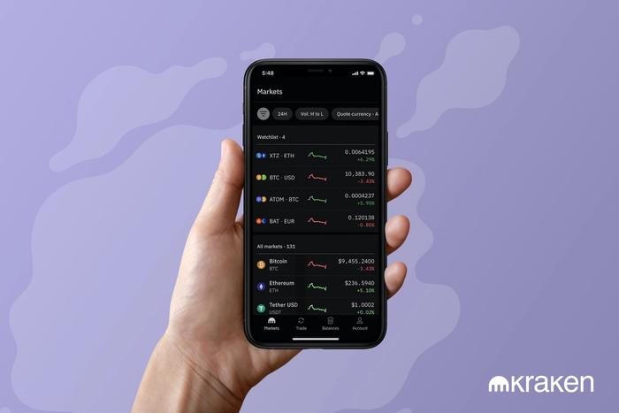 Une main qui tient l'app de cryptos Kraken
