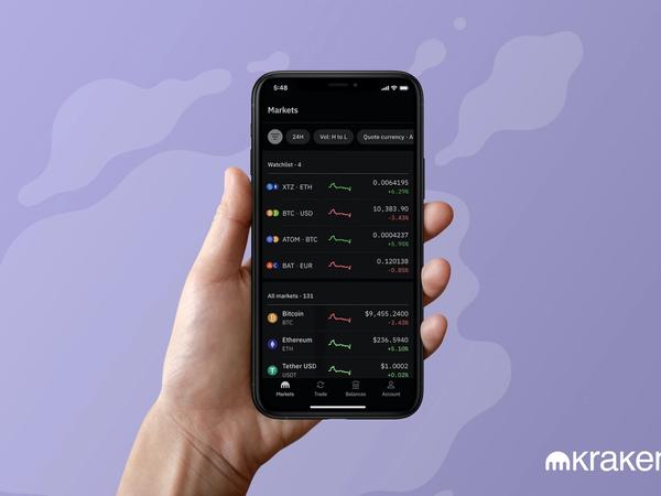 Une main qui tient l'app de cryptos Kraken