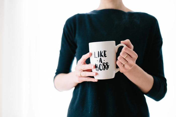 Une femme tenant un mug "like a boss"