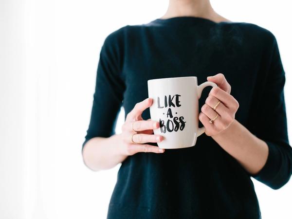 Une femme tenant un mug "like a boss"