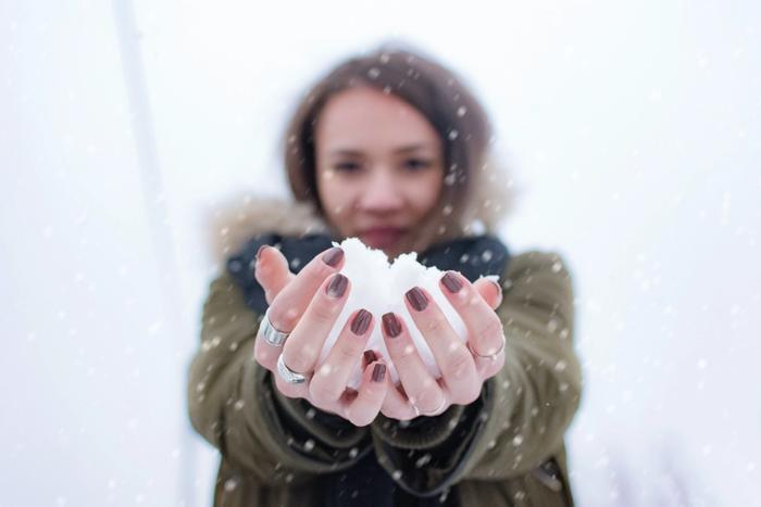 Une femme avec une boule de neige dans les mains