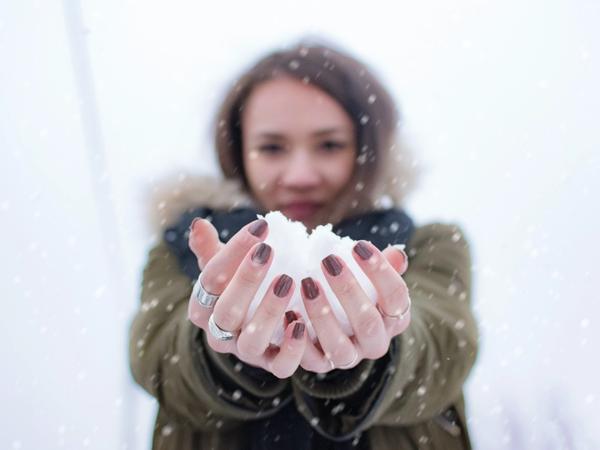 Une femme avec une boule de neige dans les mains
