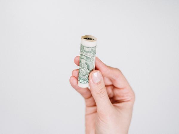 Des billets roulés dans une main