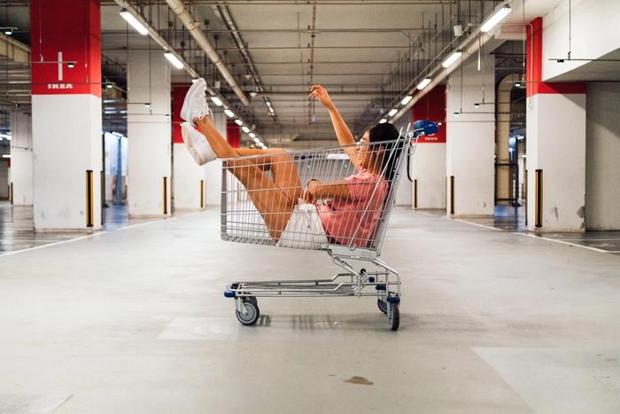 Une femme dans une caddie de supermarché