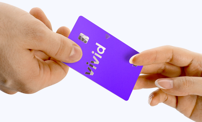 Deux mains tiennent une carte Vivid Money