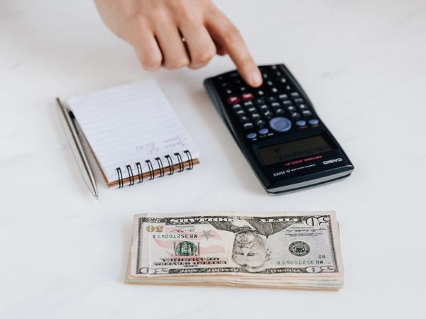 Une calculette et des dollars sur une table