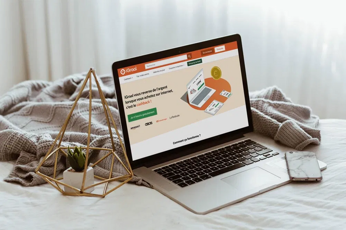 Un ordinateur posé sur un lit avec une page ouverte sur iGraal