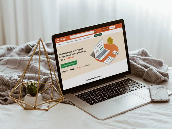 Un ordinateur posé sur un lit avec une page ouverte sur iGraal