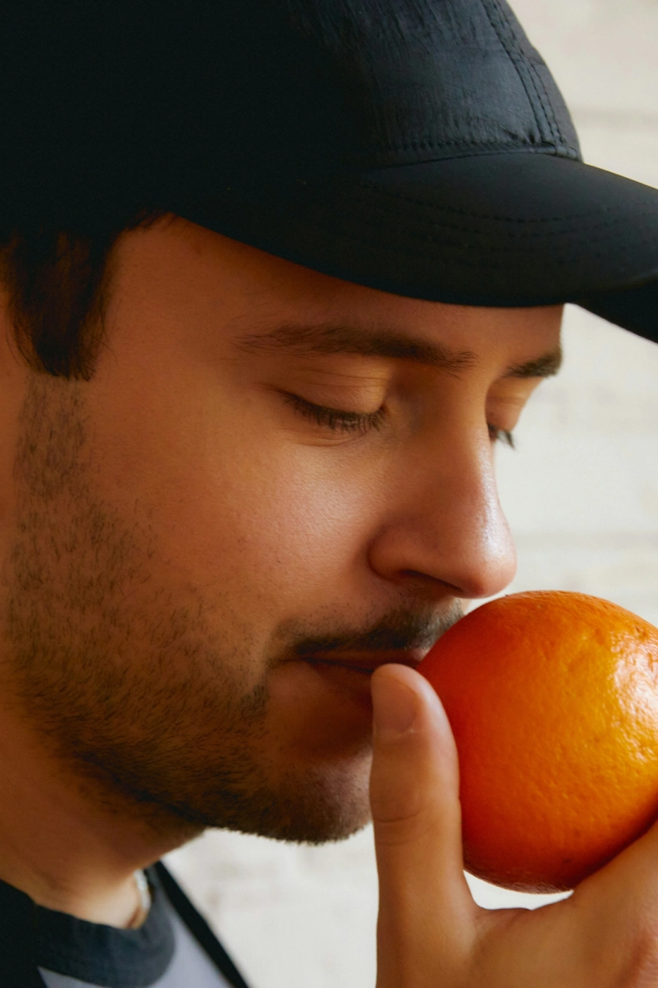 hombre oliendo una naranja