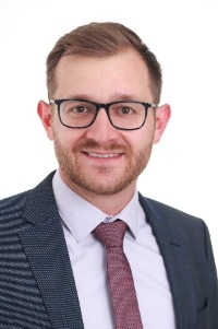 Max Najork in a Suit looking at the camera