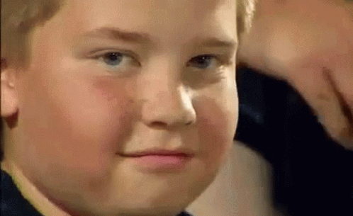 A young boy wiggling his eyebrows and staring into the camera
