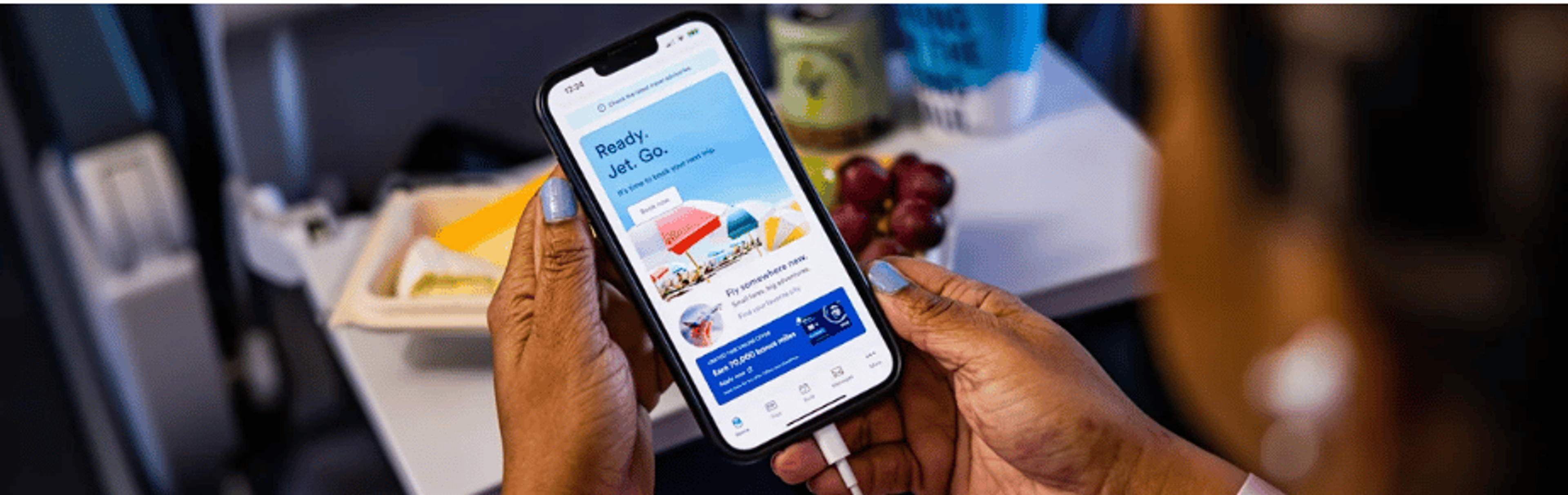 Image of soneoneholding a cellphone with the Alaska Airlines app open