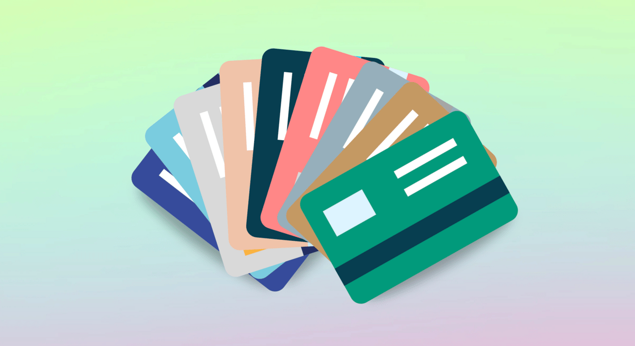 Credit cards fanned out on a pink and green ombre background