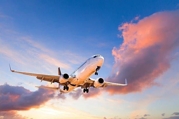 A stock photo of a plane with a sunset in the background