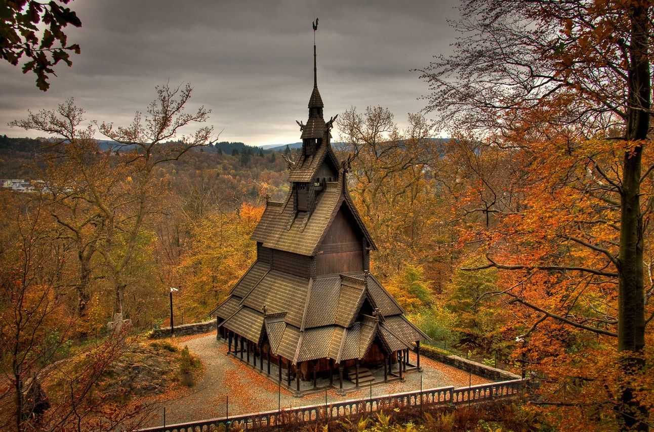 An angled and vertical church amongst fall-colored trees